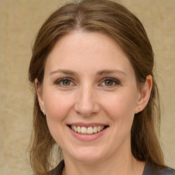 Joyful white young-adult female with medium  brown hair and green eyes