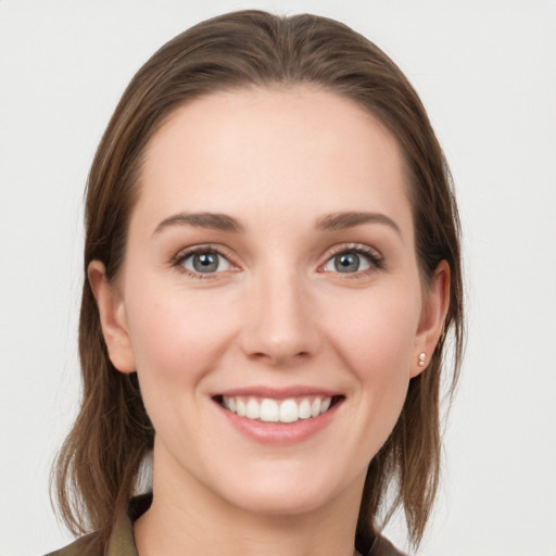 Joyful white young-adult female with long  brown hair and grey eyes