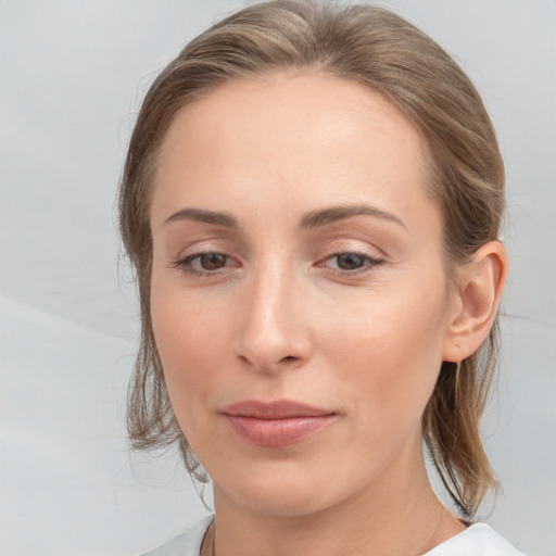 Joyful white young-adult female with medium  brown hair and grey eyes