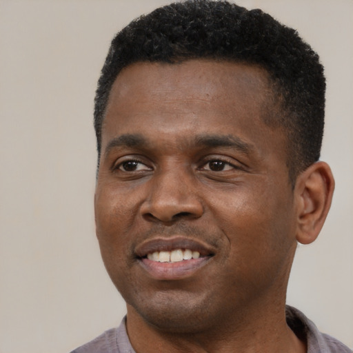 Joyful black young-adult male with short  black hair and brown eyes