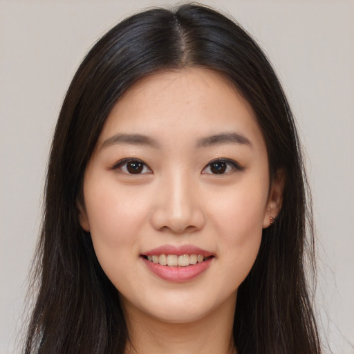 Joyful asian young-adult female with long  brown hair and brown eyes