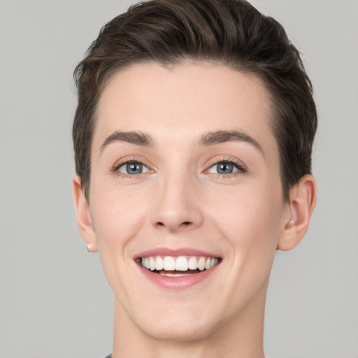 Joyful white young-adult female with short  brown hair and grey eyes