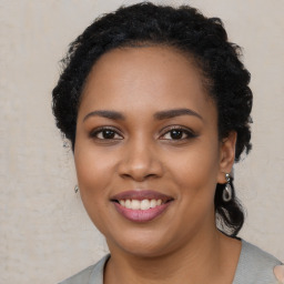 Joyful black young-adult female with long  brown hair and brown eyes