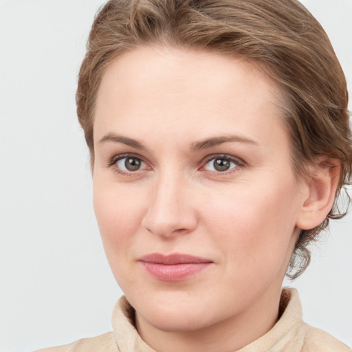 Joyful white young-adult female with short  brown hair and blue eyes