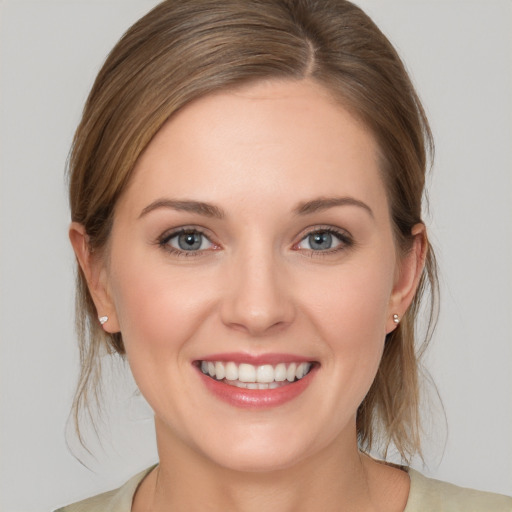 Joyful white young-adult female with medium  brown hair and grey eyes