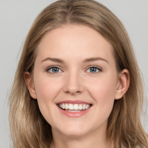 Joyful white young-adult female with long  brown hair and grey eyes