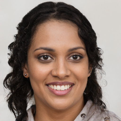 Joyful black young-adult female with long  brown hair and brown eyes