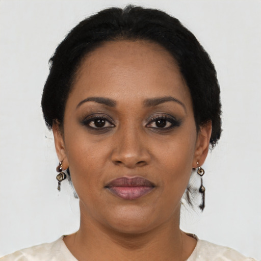 Joyful black young-adult female with short  black hair and brown eyes