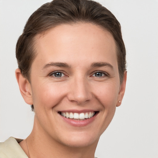 Joyful white young-adult female with short  brown hair and grey eyes