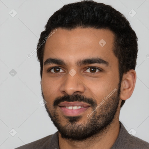 Joyful latino young-adult male with short  black hair and brown eyes