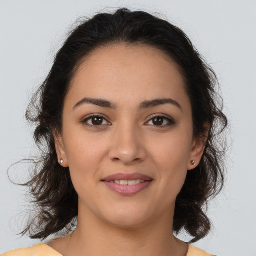 Joyful latino young-adult female with medium  brown hair and brown eyes
