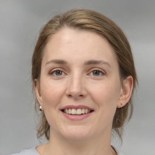 Joyful white young-adult female with medium  brown hair and grey eyes