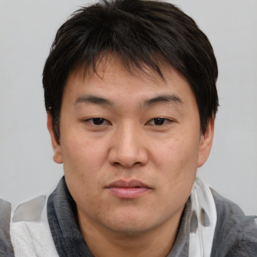 Joyful asian young-adult male with short  brown hair and brown eyes