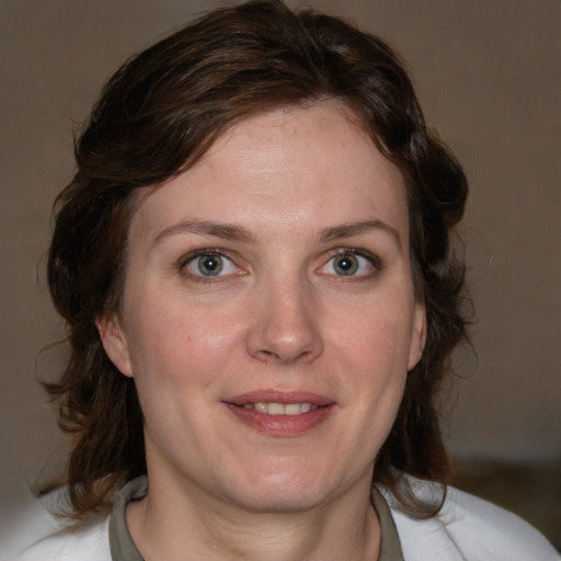 Joyful white adult female with medium  brown hair and blue eyes