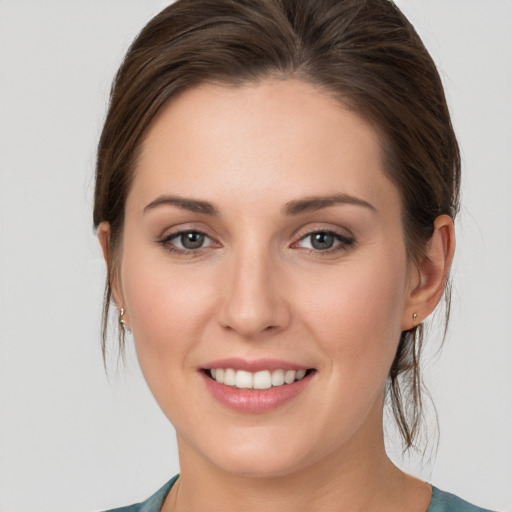 Joyful white young-adult female with medium  brown hair and grey eyes