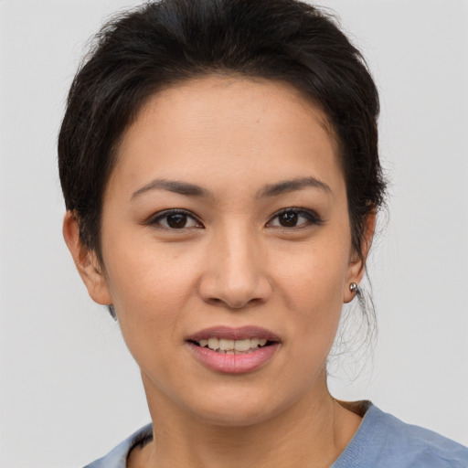 Joyful asian young-adult female with short  brown hair and brown eyes