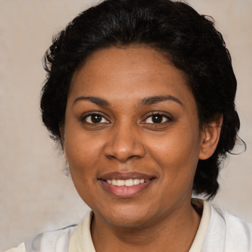 Joyful black adult female with medium  brown hair and brown eyes