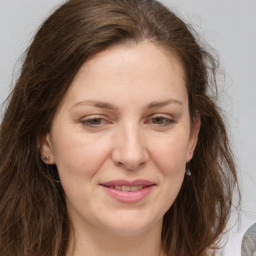 Joyful white adult female with long  brown hair and brown eyes