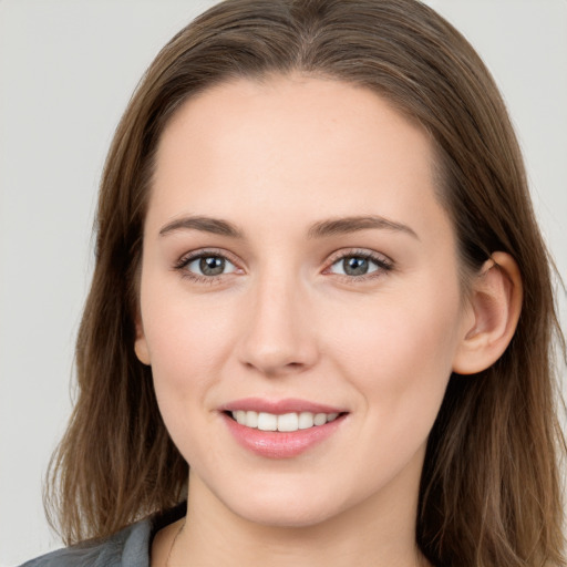 Joyful white young-adult female with long  brown hair and grey eyes