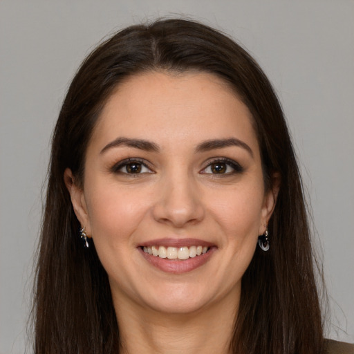 Joyful white young-adult female with long  brown hair and brown eyes