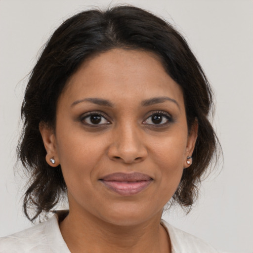 Joyful black young-adult female with medium  brown hair and brown eyes