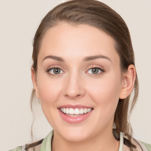 Joyful white young-adult female with medium  brown hair and green eyes