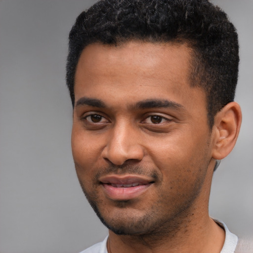 Joyful black young-adult male with short  black hair and brown eyes