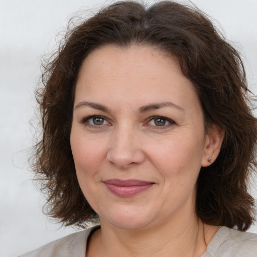 Joyful white adult female with medium  brown hair and brown eyes