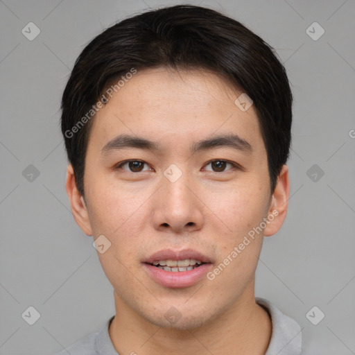 Joyful asian young-adult male with short  brown hair and brown eyes