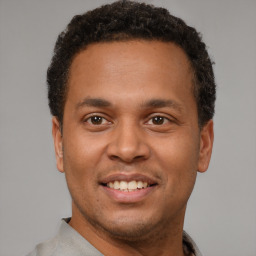 Joyful latino young-adult male with short  brown hair and brown eyes