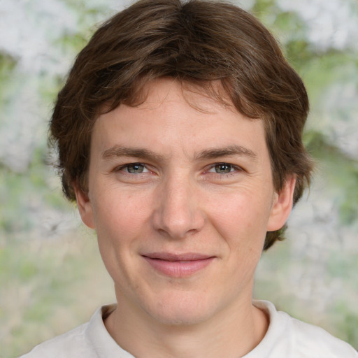 Joyful white young-adult male with short  brown hair and green eyes