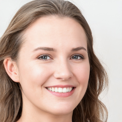 Joyful white young-adult female with long  brown hair and blue eyes