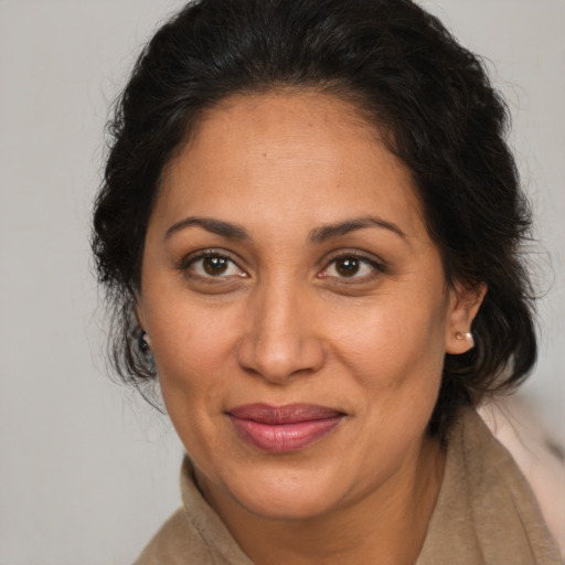 Joyful latino adult female with long  brown hair and brown eyes