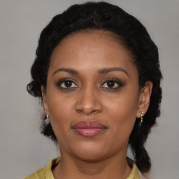 Joyful black young-adult female with medium  brown hair and brown eyes