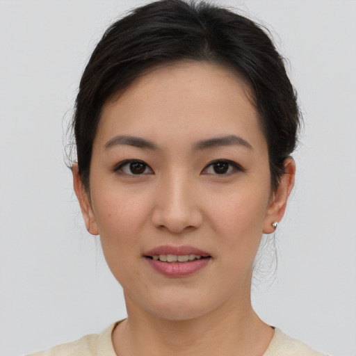 Joyful asian young-adult female with short  brown hair and brown eyes