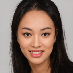 Joyful asian young-adult female with long  brown hair and brown eyes