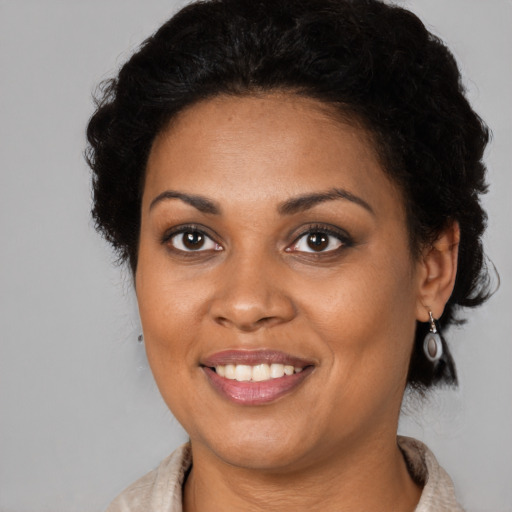 Joyful black young-adult female with medium  brown hair and brown eyes