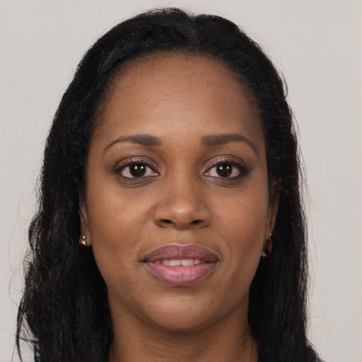 Joyful black young-adult female with long  brown hair and brown eyes