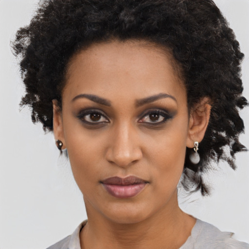Joyful black young-adult female with long  brown hair and brown eyes