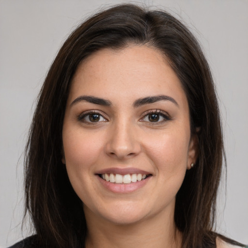 Joyful white young-adult female with long  brown hair and brown eyes