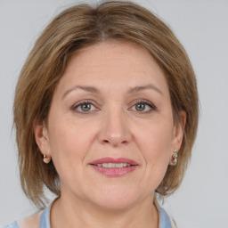 Joyful white adult female with medium  brown hair and grey eyes