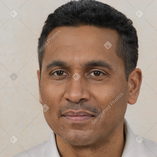 Joyful latino adult male with short  black hair and brown eyes