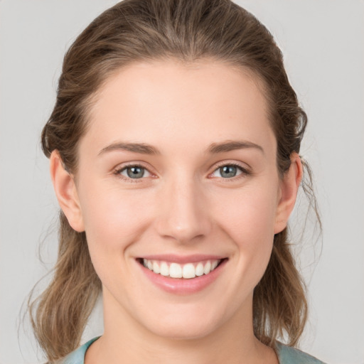 Joyful white young-adult female with medium  brown hair and grey eyes