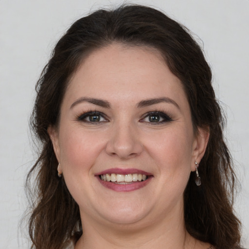 Joyful white young-adult female with long  brown hair and grey eyes