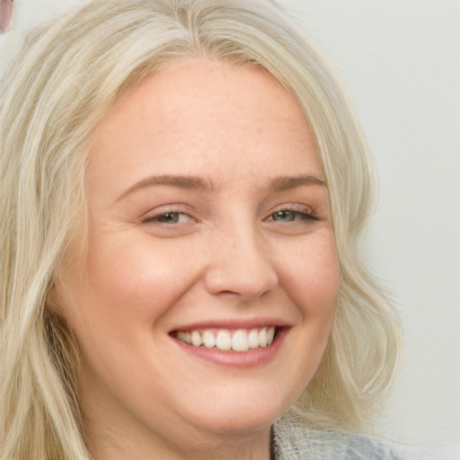 Joyful white young-adult female with long  blond hair and blue eyes