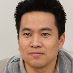 Joyful asian adult male with short  black hair and brown eyes