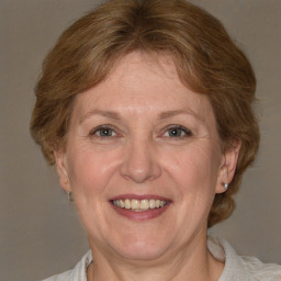 Joyful white adult female with medium  brown hair and blue eyes