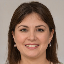 Joyful white young-adult female with long  brown hair and grey eyes