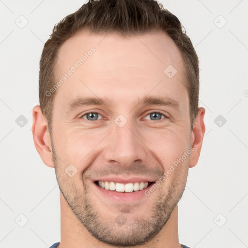 Joyful white young-adult male with short  brown hair and grey eyes