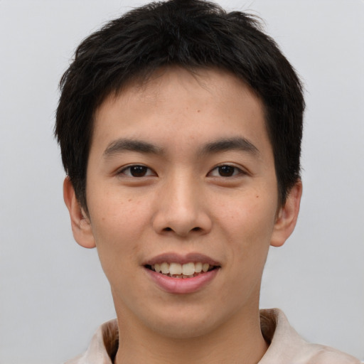 Joyful asian young-adult male with short  brown hair and brown eyes